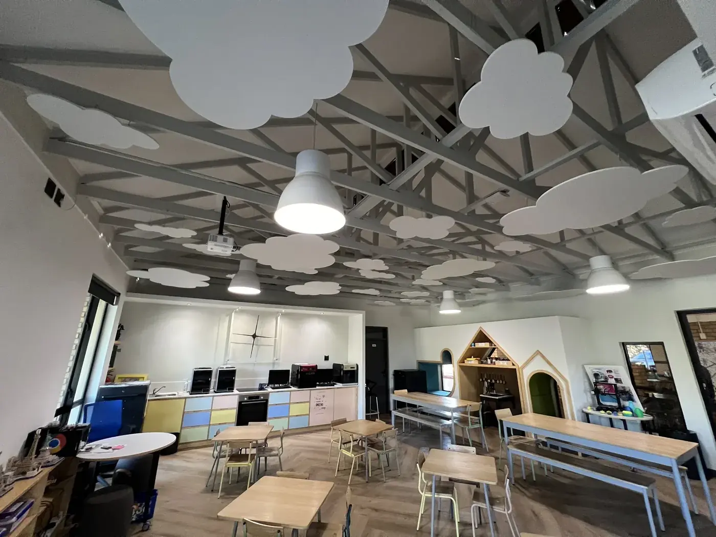 The learning hall from the far end, with acoustic clouds across the whole ceiling