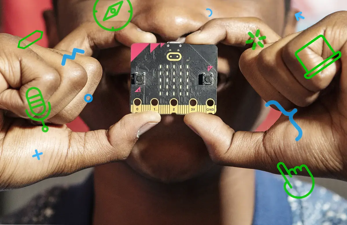Hands holding a BBC micro:bit board